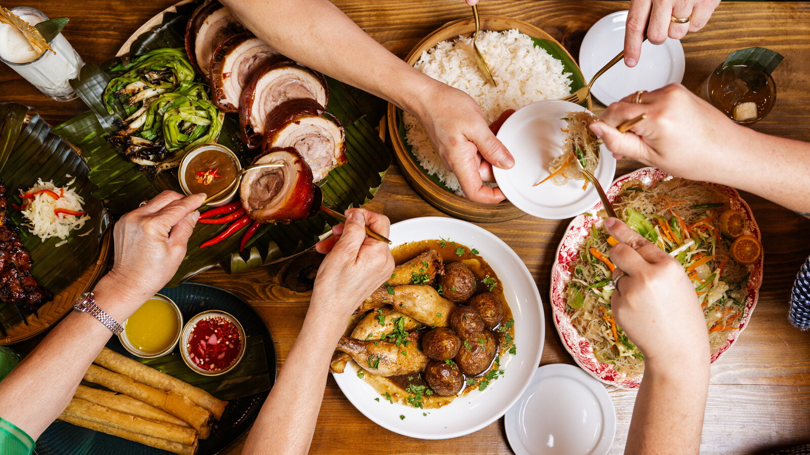 Photo of a shared Filipino meal at Lasang Pinoy, featured in an article about the restaurant in Rogers City Lifestyle magazine.